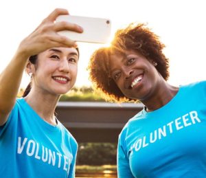 women snapping a selfie in volunteer t-shirts